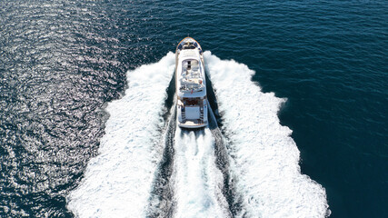 Aerial drone photo of large luxury yacht with wooden deck cruising in high speed in deep blue Aegean sea