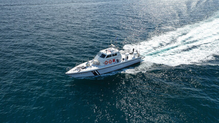 Aerial drone ultra wide photo of Hellenic Coast guard powerboat cruising in high speed near port of Piraeus, Attica, Greece