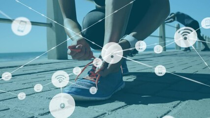 Network of connection icons against woman tying her shoelaces - Powered by Adobe