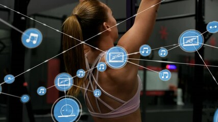 Network of connection icons against woman performing pull up exercise at the gym - Powered by Adobe