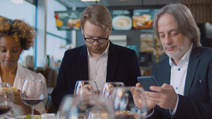 Diverse people with mobile phone addiction in restaurant surfing internet