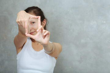 Woman doing yoga mudra of hands putting fingers together and hiding and peeking out from behind...