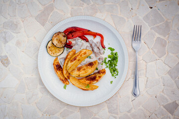 Traditional oven potatoes with veggies and goulash.