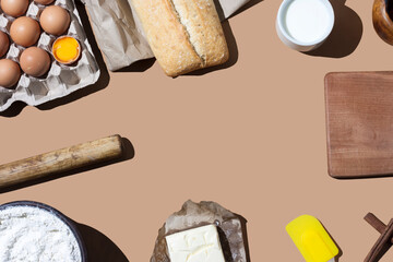 Frame made of ingredients for making dough. Recipe for baking flour products. Flour, butter, eggs, yeast, flour, milk, kitchen utensils on the table. Ingredients, baking utensils. Top view, copy space