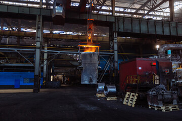 Iron casting at the foundry. Overhead crane with ladle with molten metal at metallurgical factory