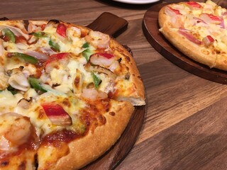 Delicious and colorful freshly baked pizza served on wooden tray for food sharing concept
