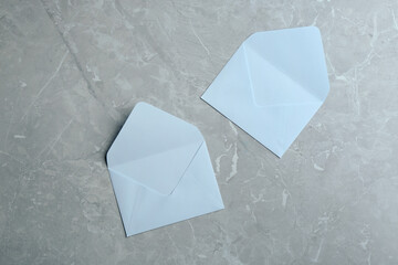 White paper envelopes on grey marble background, flat lay