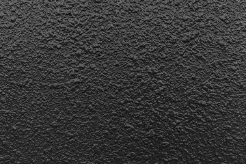 Rough patterned black cement wall texture and seamless background