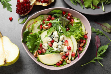 Tasty salad with pear slices and fresh ingredients on grey table, flat lay