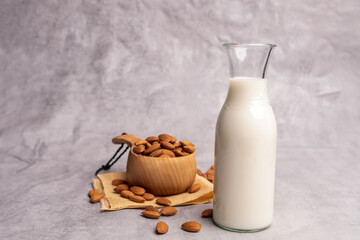 Almond milk in a small bottle  with almonds