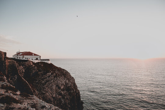 Lighthouse at sunset on rocky cliffs in summer in Sagres, Portugal