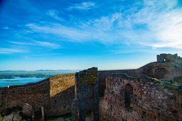View of castle walls with hills on horizon and blue sky