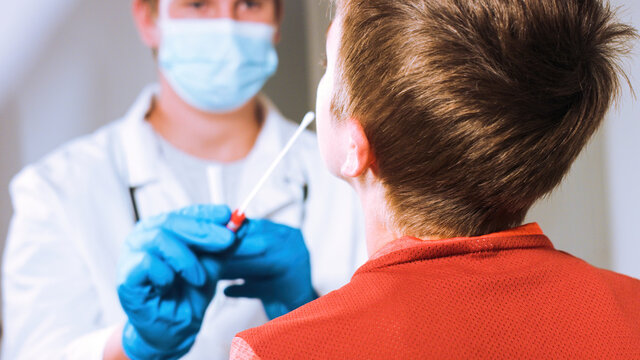 Doctor Takes A Cotton Swab Coronavirus Test From Child Nose To Analyse If Postitve For Covid-19.