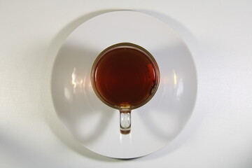 A ceramic plate with a cup of strong tea on it.