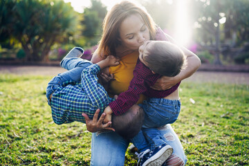 Single mother have playful time with twin sons in nature park - Family, mother and children love