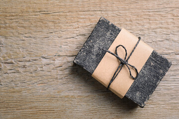 Natural tar soap on wooden table, top view. Space for text