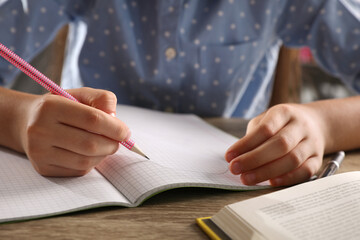 Preteen girl doing homework at table, closeup