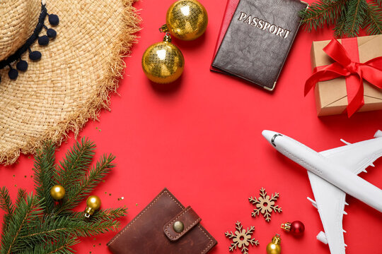 Frame of Christmas decorations, passports and space for text on red background, flat lay. Winter vacation