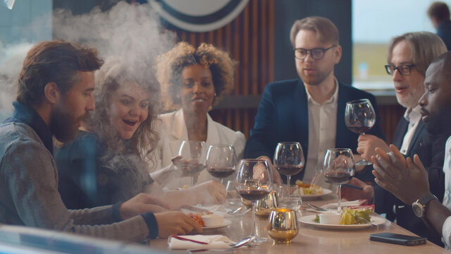 Diverse friends enjoying delicious food dining in modern restaurant