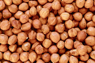 Macro shot of many peeled Hazelnuts mixed with nuts in nutshell. Concept of autumn harvesting. Natural and organic food full of vitamins. Seasonal vegetarian nutrition.