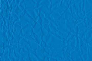 Blue vintage and old looking crumpled paper background. Retro cardboard texture. Grunge paper for drawing. Ancient book page. Present wrapping.