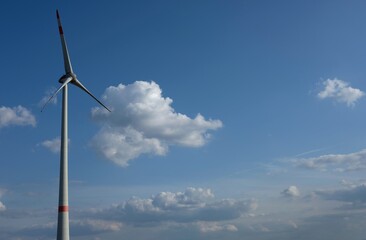 wind turbine against blue sky with clouds - 386458975