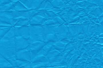 Blue vintage and old looking crumpled paper background. Retro cardboard texture. Grunge paper for drawing. Ancient book page. Present wrapping.