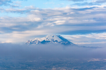 Chimborazo and Carihuayrazo volcanoes at sunrise with the city of Ambato