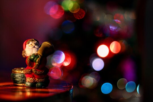 Mu&ntilde;eco de porcelana de Santa Claus con luces de fondo con efecto bokeh