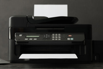 Modern printer with paper on grey table, closeup