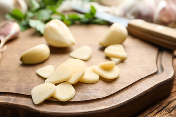 Fototapeta na wymiar Fresh whole and cut garlic on wooden table, closeup. Organic product