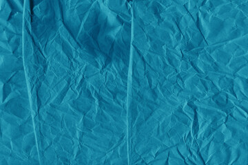 Blue vintage and old looking crumpled paper background. Retro cardboard texture. Grunge paper for drawing. Ancient book page. Present wrapping.