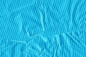 Blue vintage and old looking crumpled paper background. Retro cardboard texture. Grunge paper for drawing. Ancient book page. Present wrapping.