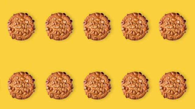 seamless looping animation of peanut cookies. two rows of homemade pastries animated on a yellow background