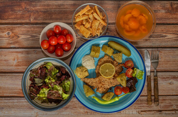 Vegetable fruit yoghurt apricot courgette chicken on blue plate and wooden table