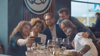 Business people having meeting in indoor restaurant and taking selfie
