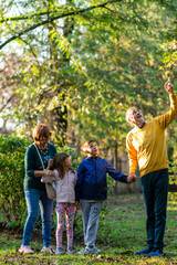 Fototapeta premium Grandparents with grandchildren posing outdoors in autumn. 