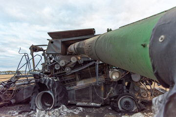 Side View of Burnt Combine Harvester on Grain Field in Rural North Dakota, taken at Daytime with Cloudy Sky.