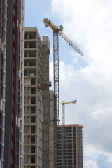 Construction of modern multi-storey buildings. New development of a residential area. House frames and construction cranes at the construction site.