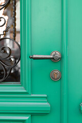 Vintage decorative handle and lock on green wooden door