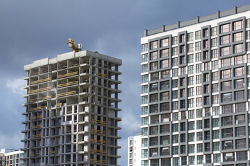 Construction of modern multi-storey buildings. New development of a residential area. House frames and exterior work on the construction site.