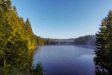 Fototapeta na wymiar Ein See im Nebel am Morgen mit Sonnenstrahlen Fichtelsee Fichtelgebirge