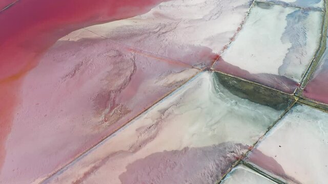 Aerial video flying over pink salt lake water from drone. Genichesk, Ukraine. 4k UHD footage