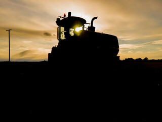 Tractor Silhouette in Field at Sunset in North Dakota.