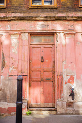 Portrait View of a Deteriorated Red Door and a Little Girl Painted on a Wall
