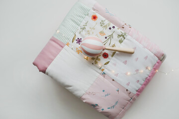Pink patchwork blanket top view.  Cozy baby girl cot with blanket. Bedding and textile for children...