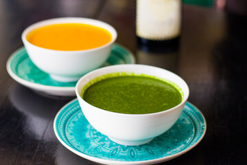 Green and yellow cream soup on the restaurants table, pumpkin and spinach