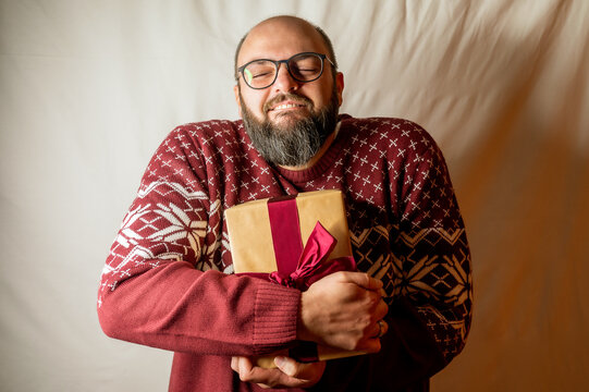 a man holds his present with his eyes closed and happily hugged