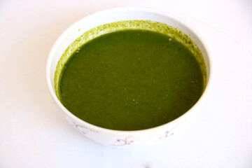 Green chutney(sauce) in white bowl with white isolate background