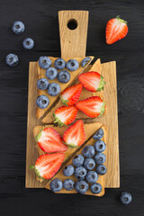 Top view of sandwiches with peanut butter and berries on the cutting board © Liudmyla